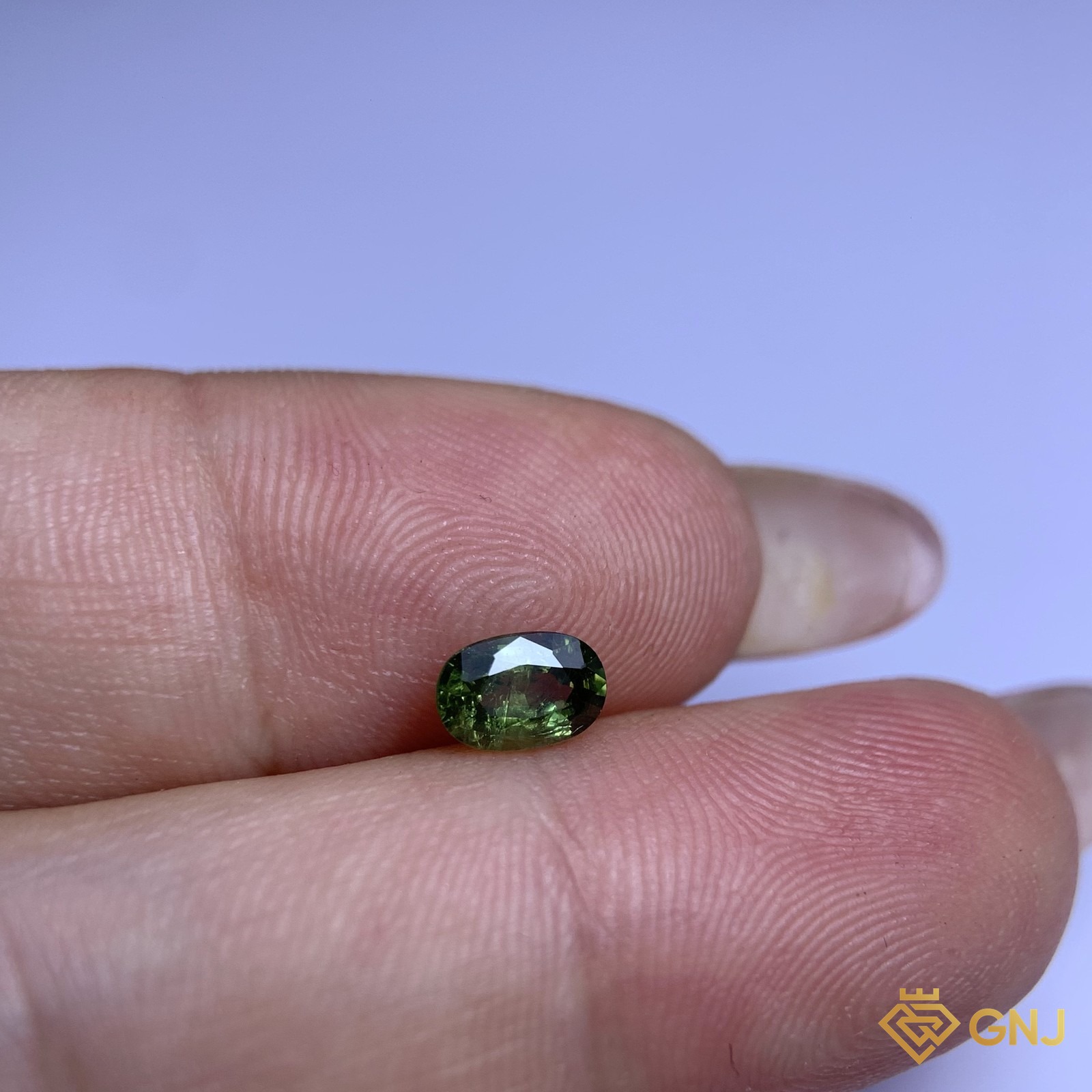 Đá sapphire xanh lá tự nhiên 0,72ct - trên tay