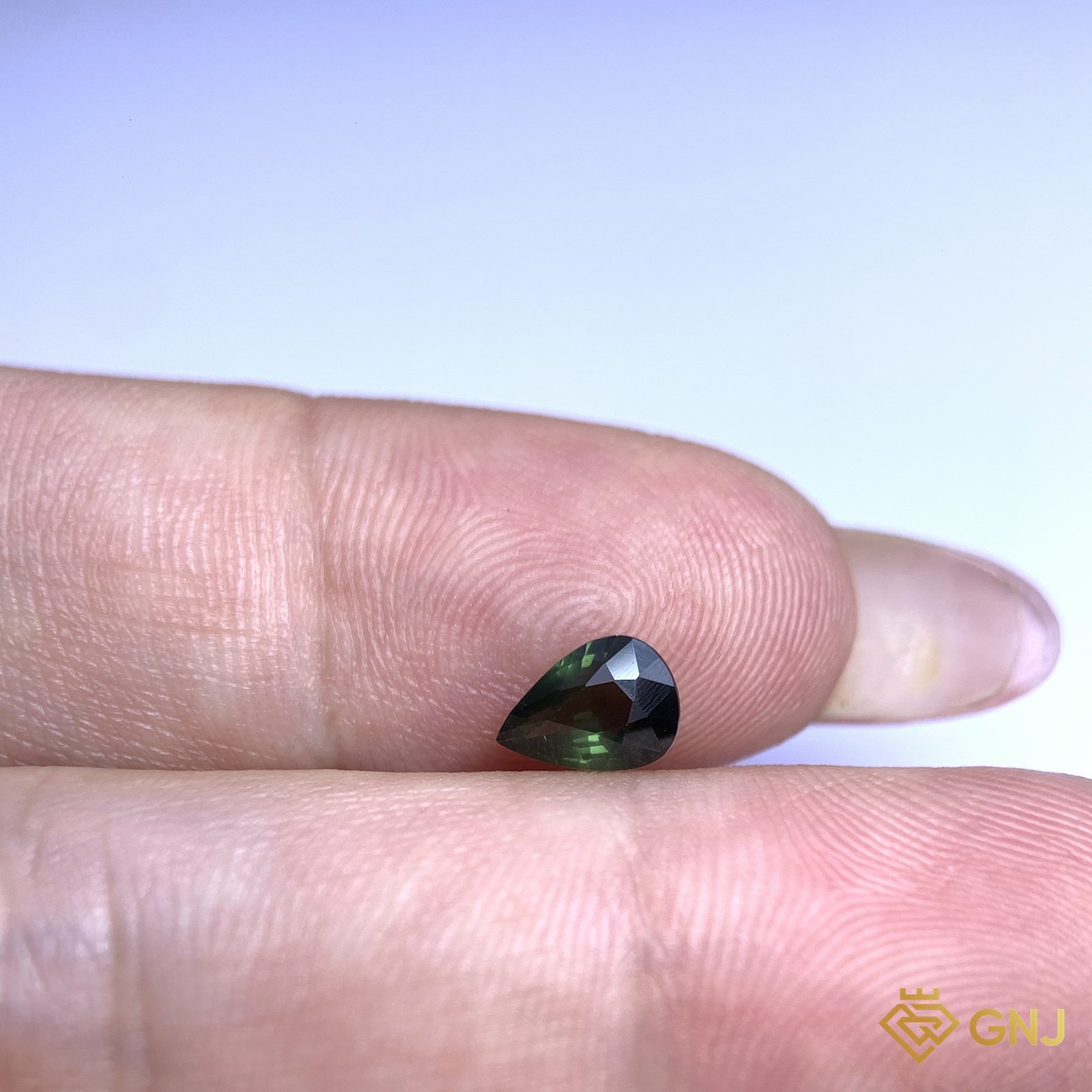 Đá sapphire xanh lá tự nhiên 0,74ct - trên tay