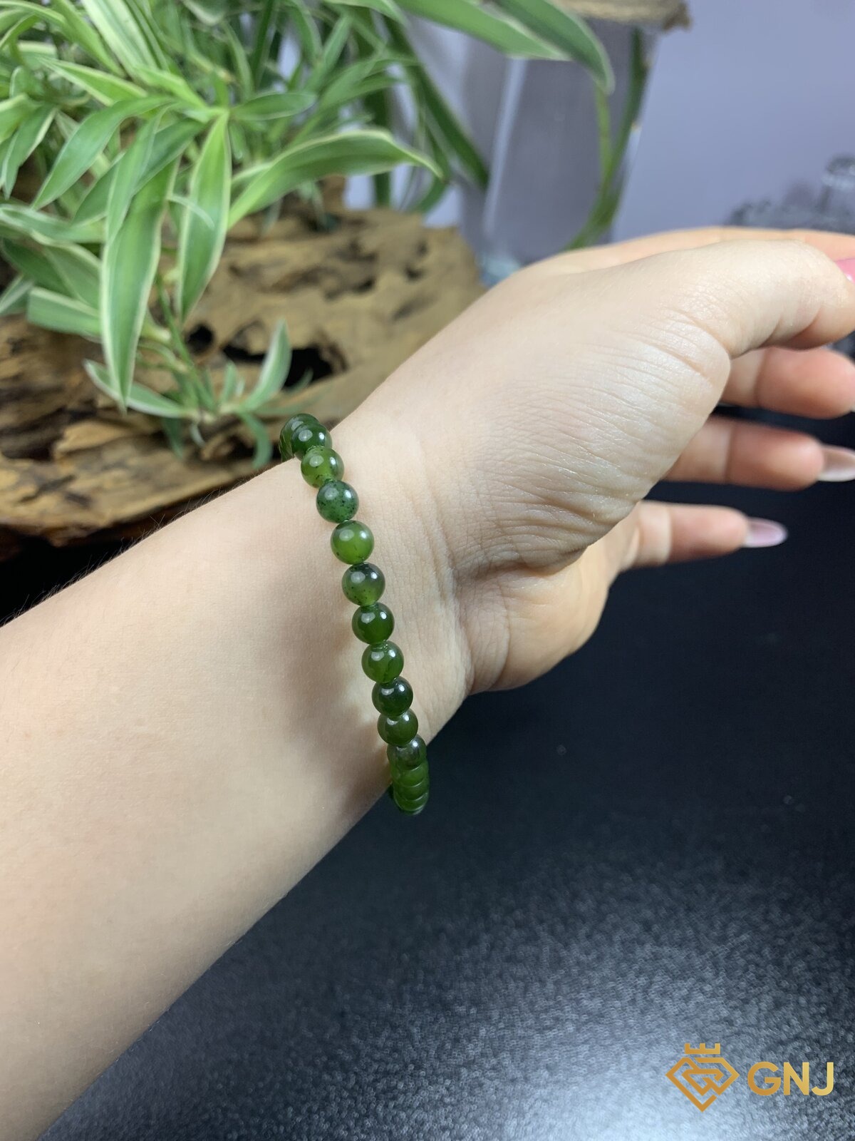 Vòng tay ngọc bích nephrite đeo trên cổ tay — thấy rõ dáng vòng và sắc xanh lục trầm