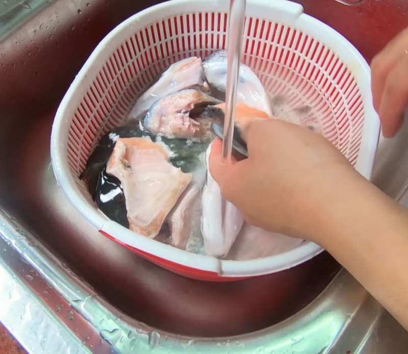 Rửa đầu cá hồi dưới vòi nước sạch