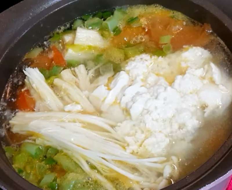 Cho nấm kim châm và đậu hũ non vào nồi canh
