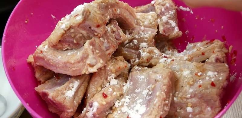 Rắc đều bột năng lên bề mặt sườn trước khi chiên