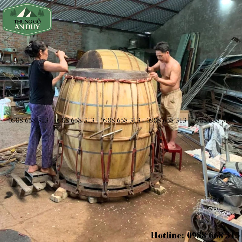 Nghệ nhân căng da trâu trong công đoạn bưng trống gỗ mít.