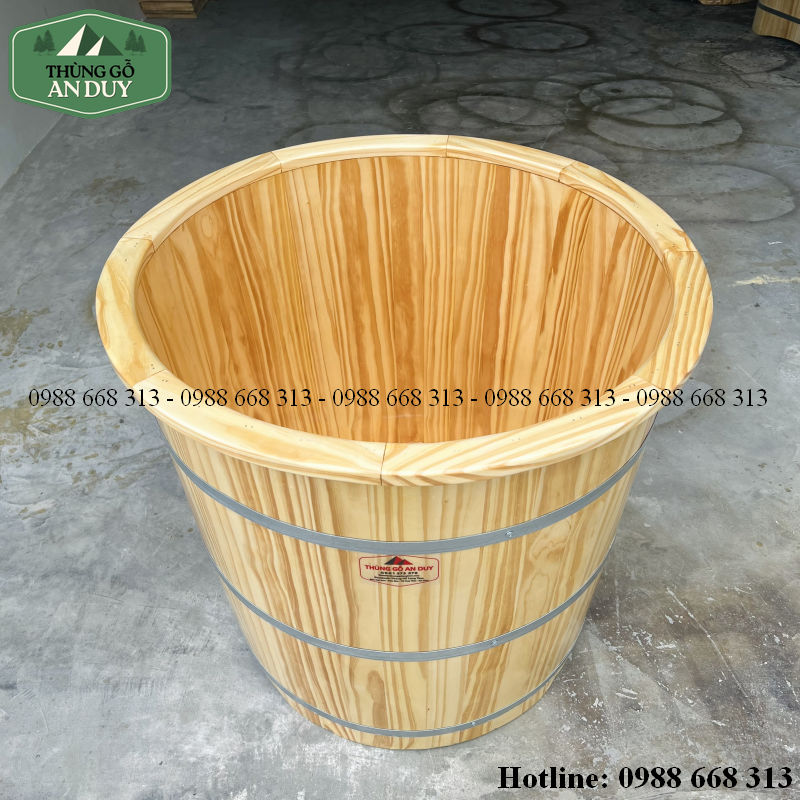 Bồn tắm gỗ thông tròn có ba đai cố định chắc chắn.