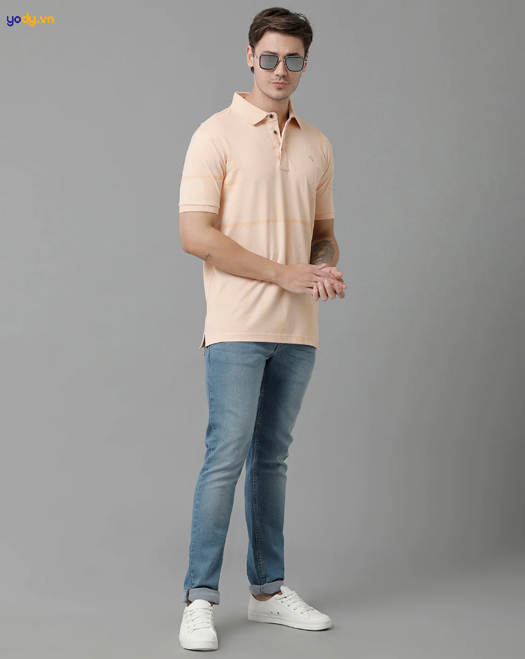 Áo polo màu kem kết hợp với quần jeans