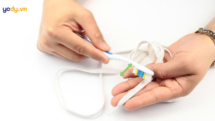 Lấy bàn chải chà nhẹ vào dây giày