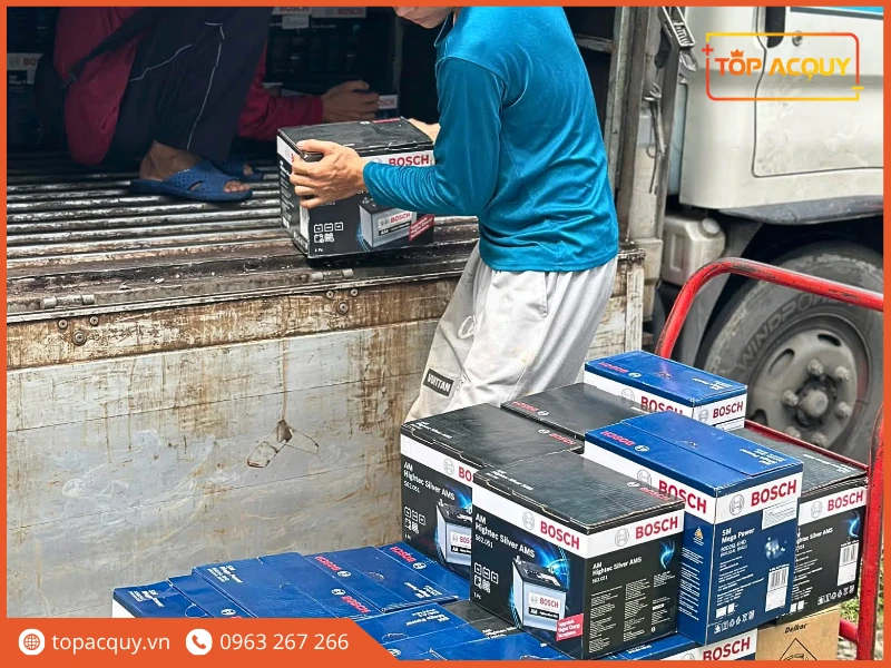 Kỹ thuật viên giao bình ắc quy Bosch từ xe tải hàng Topacquy