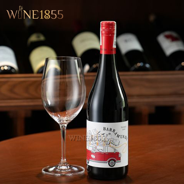Chai rượu vang Barramundi Shiraz kèm ly thuỷ tinh trên bàn gỗ