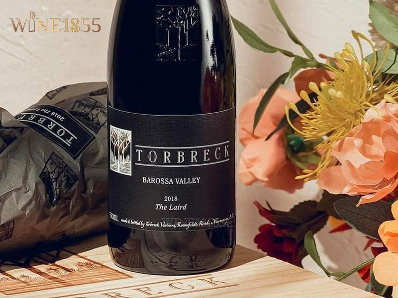 Chai rượu vang Torbreck The Laird 2018 bên hoa trang trí