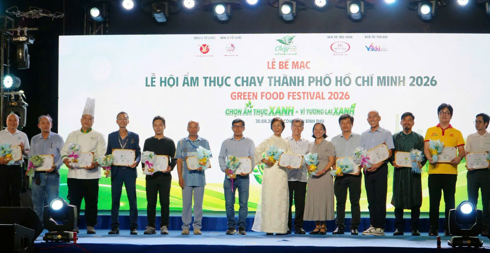 Cô Lê Thị Ngân (áo dài trắng) nhận bảng vinh danh và hoa cảm ơn tại lễ bế mạc.