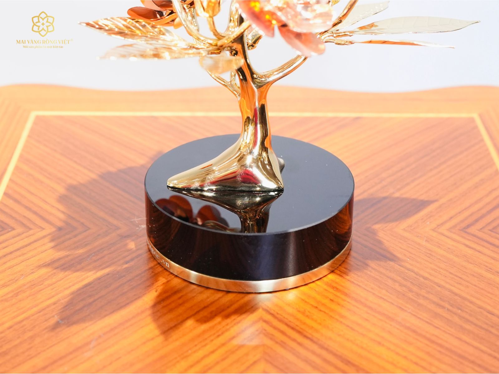Đế đá màu đen bóng dáng tròn chắc chắn và nổi bật sắc vàng 24k của cành đào