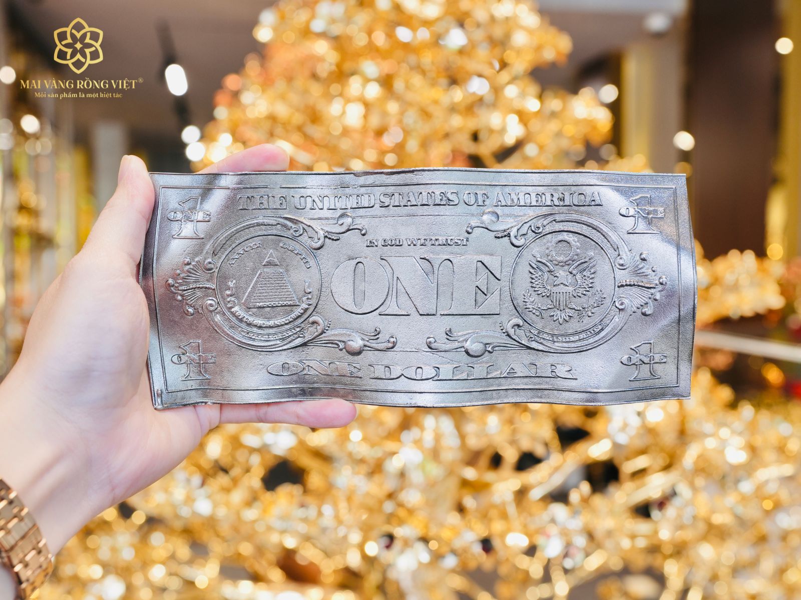 Trên tay tờ 1 dollar màu bạc mặt sau