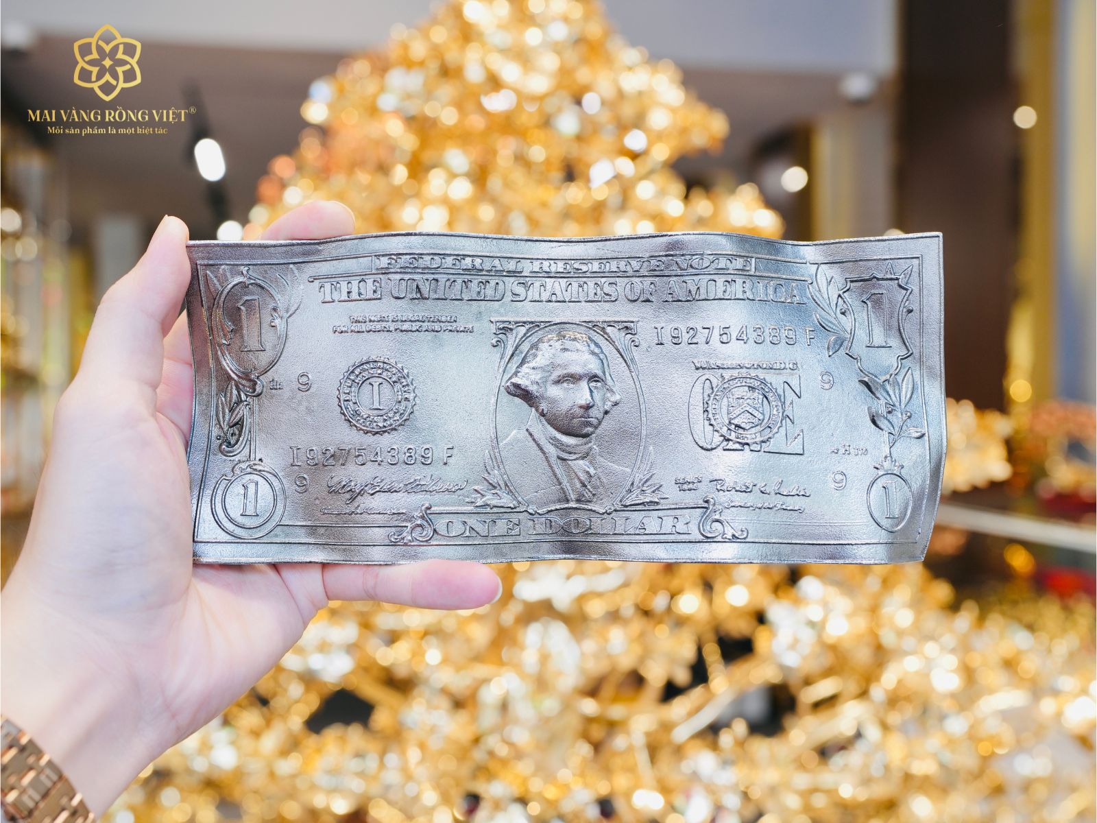 Trên tay tờ 1 dollar màu bạc mặt trước