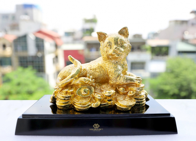 Tượng mèo kết hợp với tiền vàng giúp thu hút tài lộc vận may