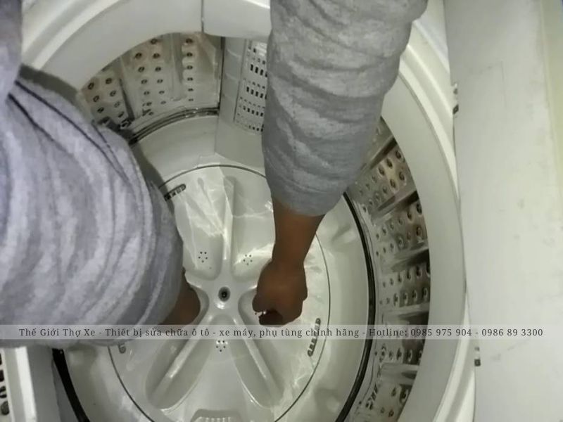 Thao tác mở ốc mâm máy giặt 