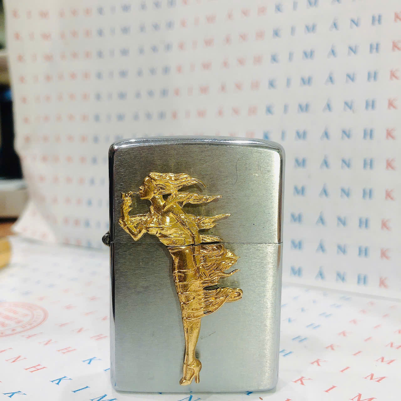 Eblem dán trang trí Zippo chủ đề Windy Gril vàng ( Cô gái gió), chất liệu đồng thau, hàng chuẩn zin Mỹ