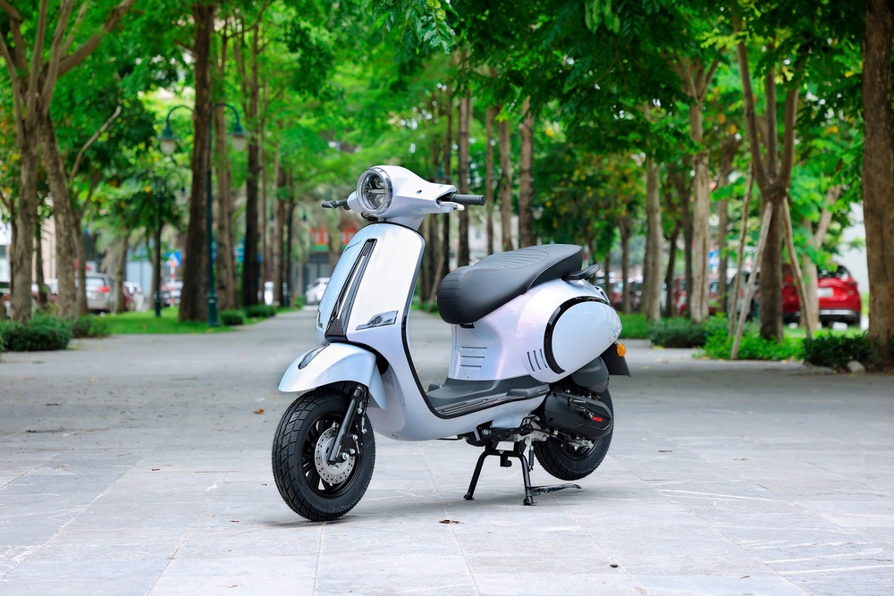 Daelim Kosmo màu xanh nhạt đỗ trên đường có hàng cây hai bên