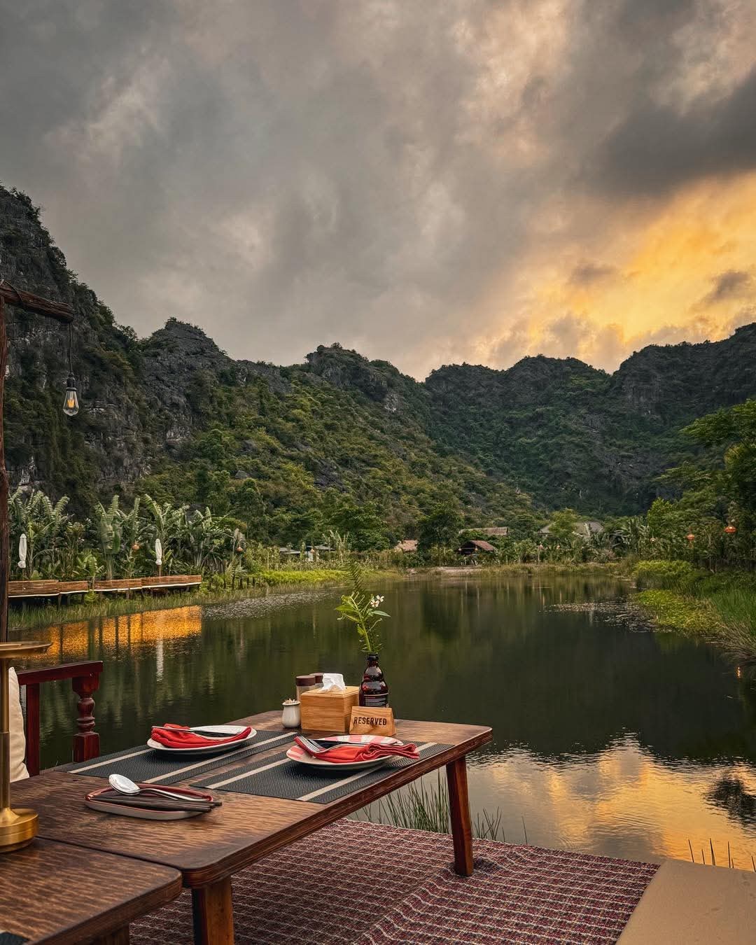 Bàn ăn bên hồ tại Lamia Bamboo Retreat trong ánh chiều