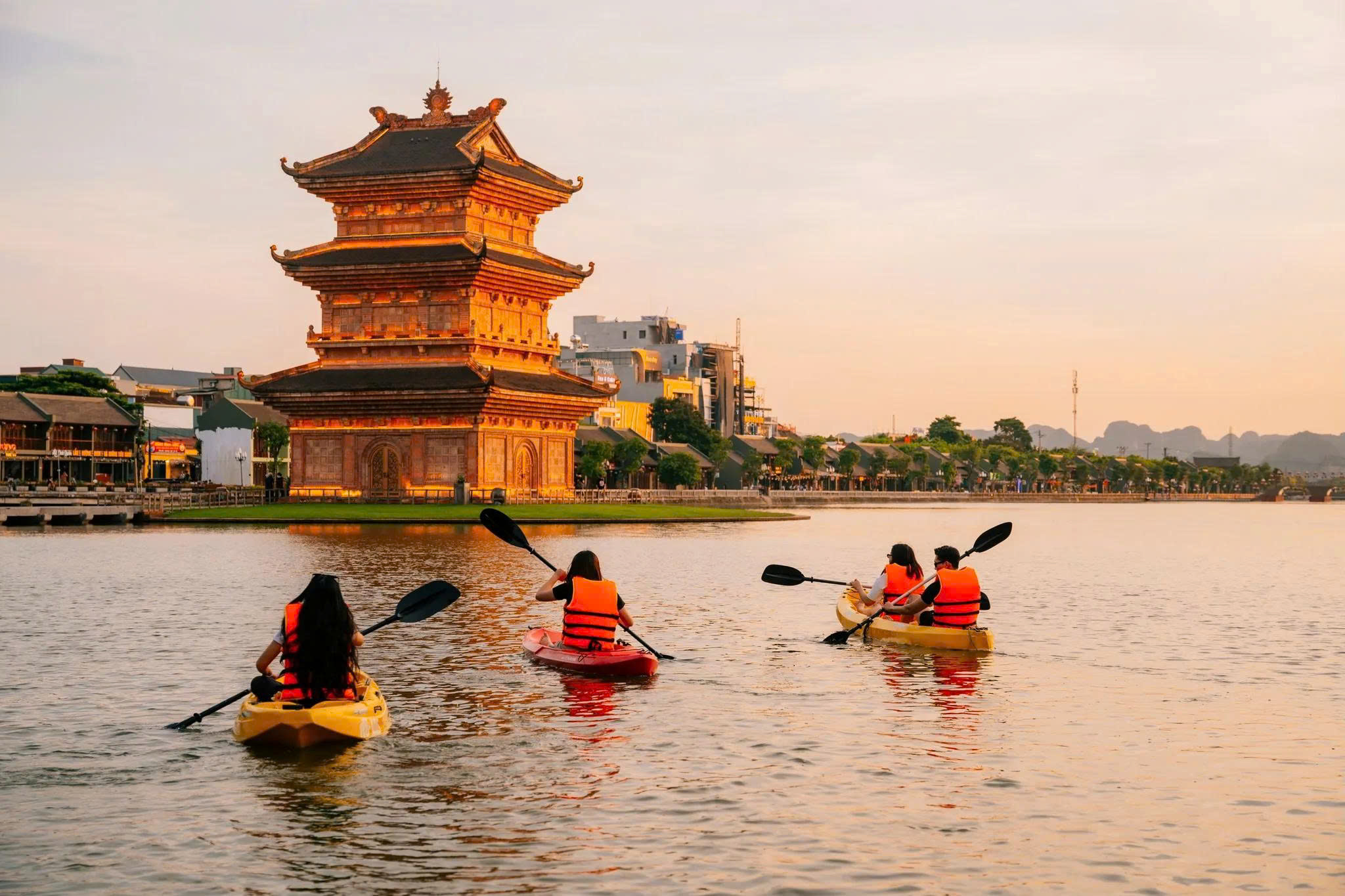 Du khách chèo thuyền trên hồ Kỳ Lân khi hoàng hôn buông xuống