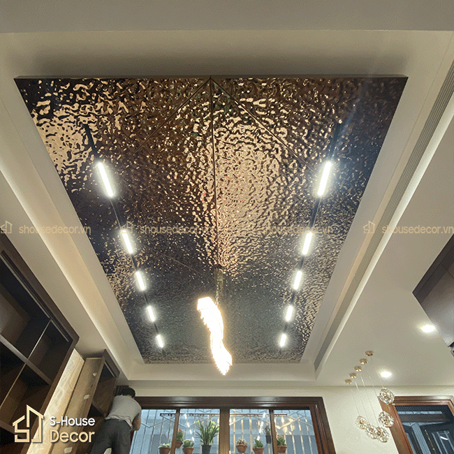 Chi tiết bề mặt inox 304 sóng nước màu trà, tạo hiệu ứng ánh sáng độc đáo cho không gian.