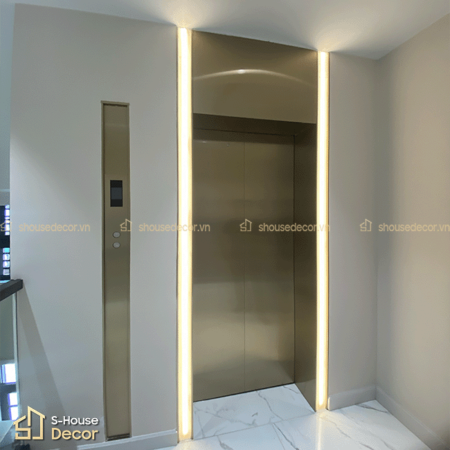 Chi tiết khung bao inox 304 xước vàng champagne được thi công sắc nét, tạo điểm nhấn nổi bật cho khu vực cửa thang máy.