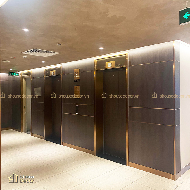 Các chi tiết line inox mảnh giúp khu vực thang máy sắc nét hơn mà không tạo cảm giác nặng thị giác.