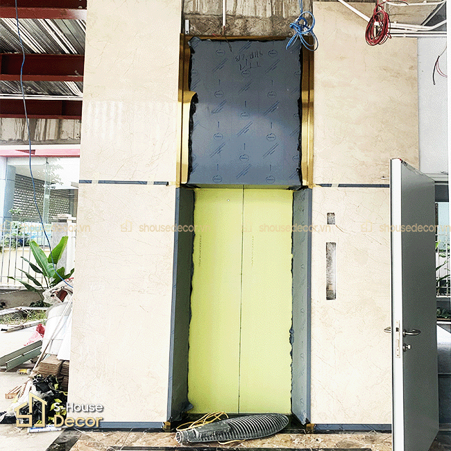 Hạng mục trang trí inox thang máy với khung bao inox 304 xước vàng bản rộng, tạo điểm nhấn sang trọng cho khu vực cửa tầng.