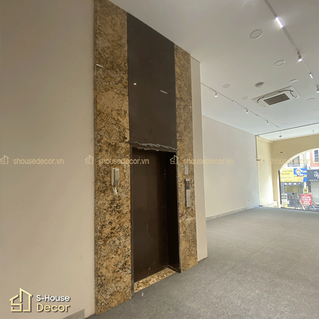 Chi tiết lan can inox mạ PVD vàng hồng đồng bộ với khu vực thang máy trong công trình.