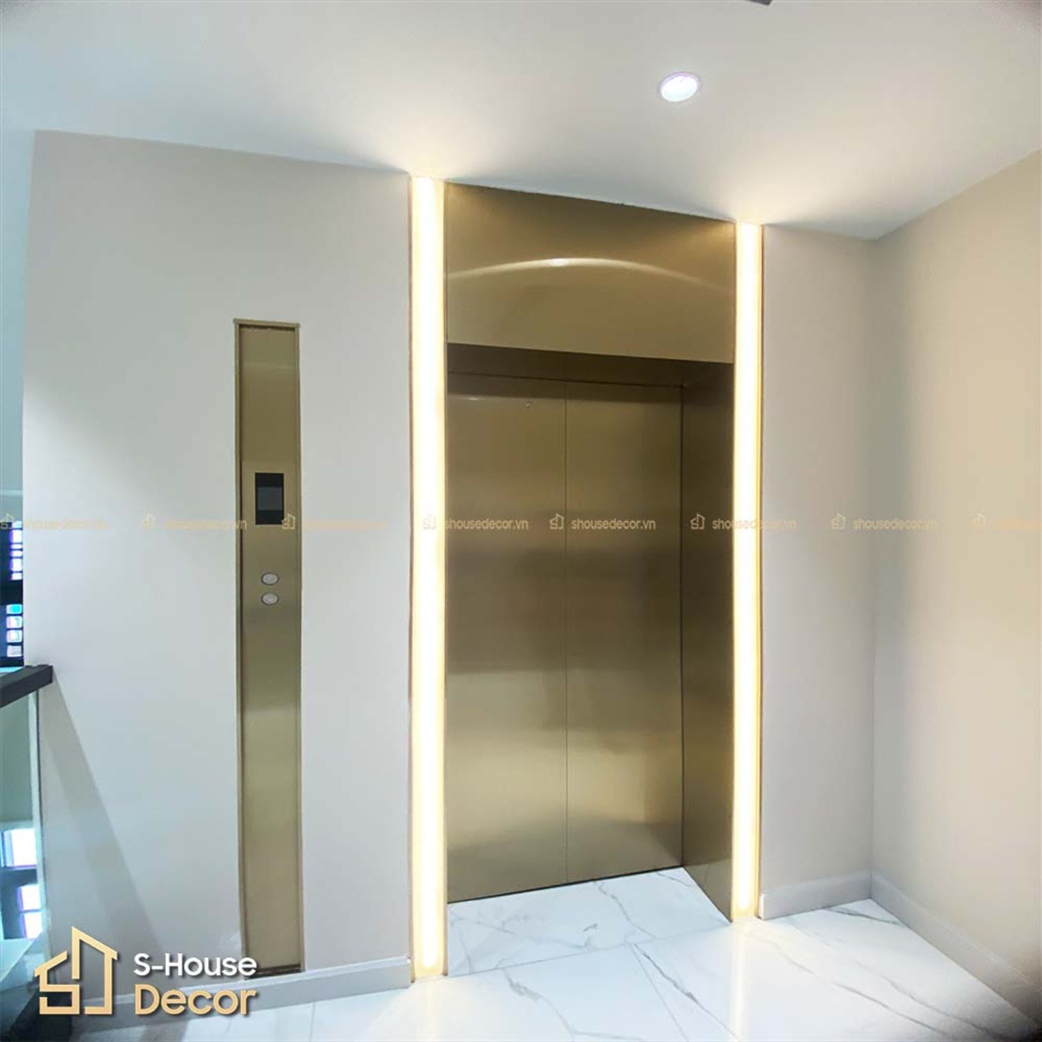 Mẫu cửa thang máy ốp inox Vàng Champagne kết hợp với đá ốp trắng tại S-House Decor