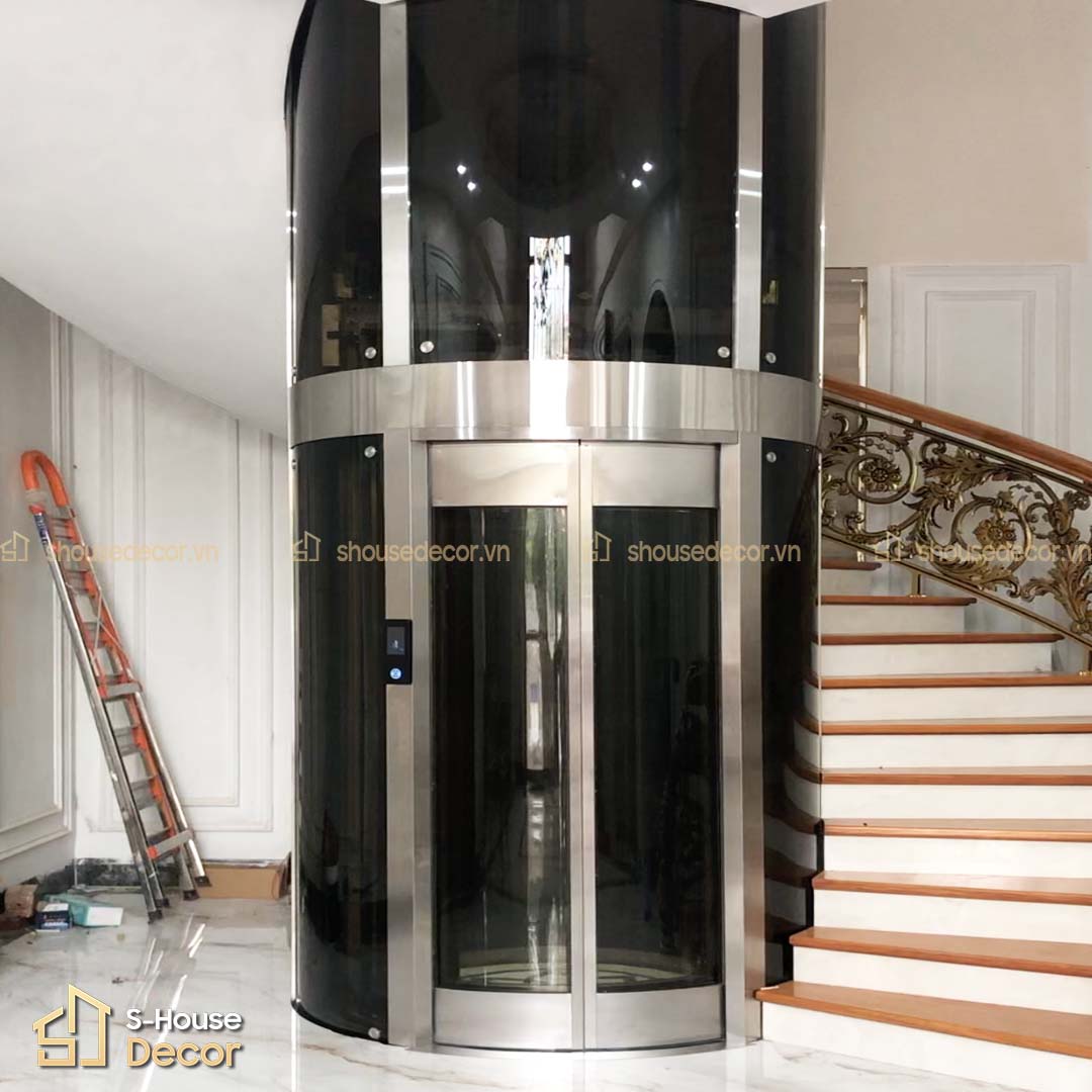 Khung thép và inox trắng xước trong thi công thang máy tròn.