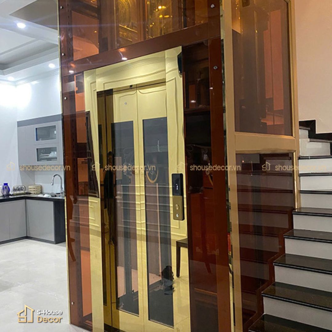 Thi công thang máy kính khung thép kết hợp inox vàng gương