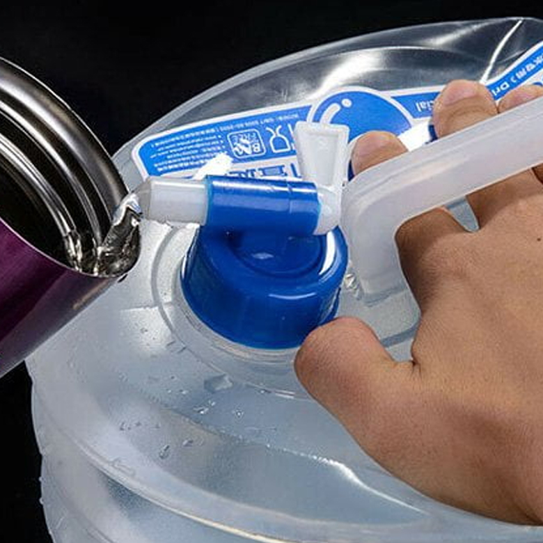 Tay người đang vặn vòi thùng nước gấp gọn để rót nước