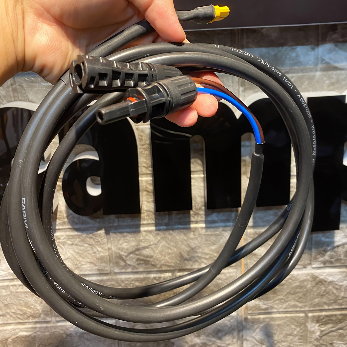 Tay cầm cuộn cáp MC4 to XT60 Solar Cable, cận cảnh đầu nối trước logo thương hiệu