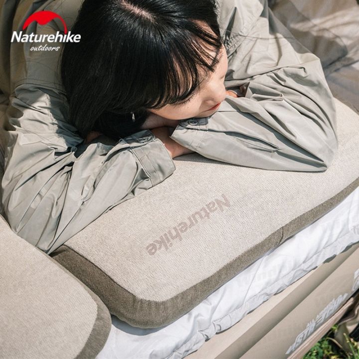 Cô gái nằm gối đầu lên gối cắm trại Naturehike trên giường