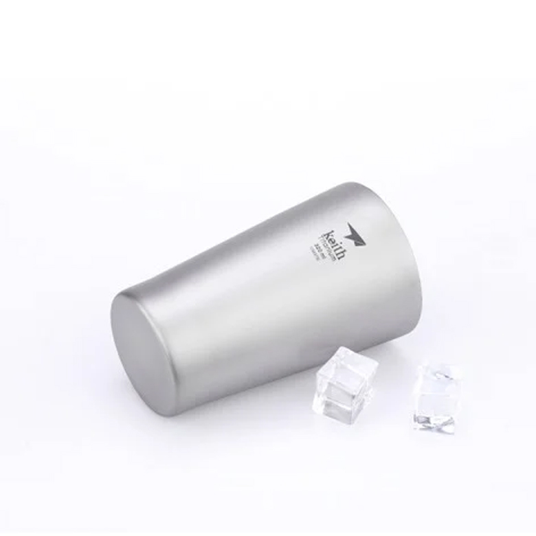 Ly Giữ Nhiệt Keith Double-wall Titanium Cup nằm nghiêng cạnh vài viên đá