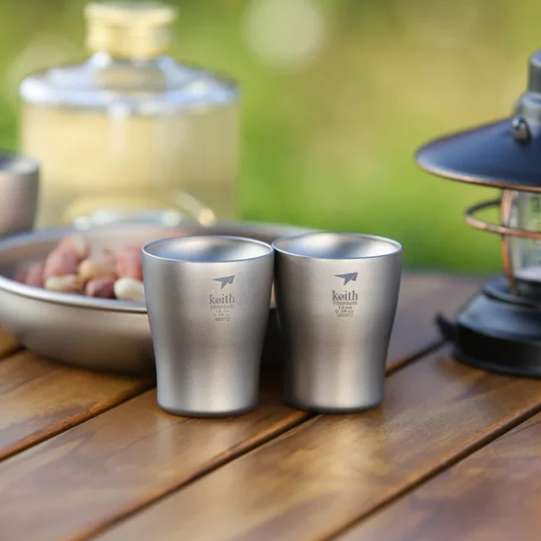 Ly Uống Rượu Keith Titanium Wine Cup 10ml hai ly trên bàn gỗ cạnh bình rượu và đèn lồng