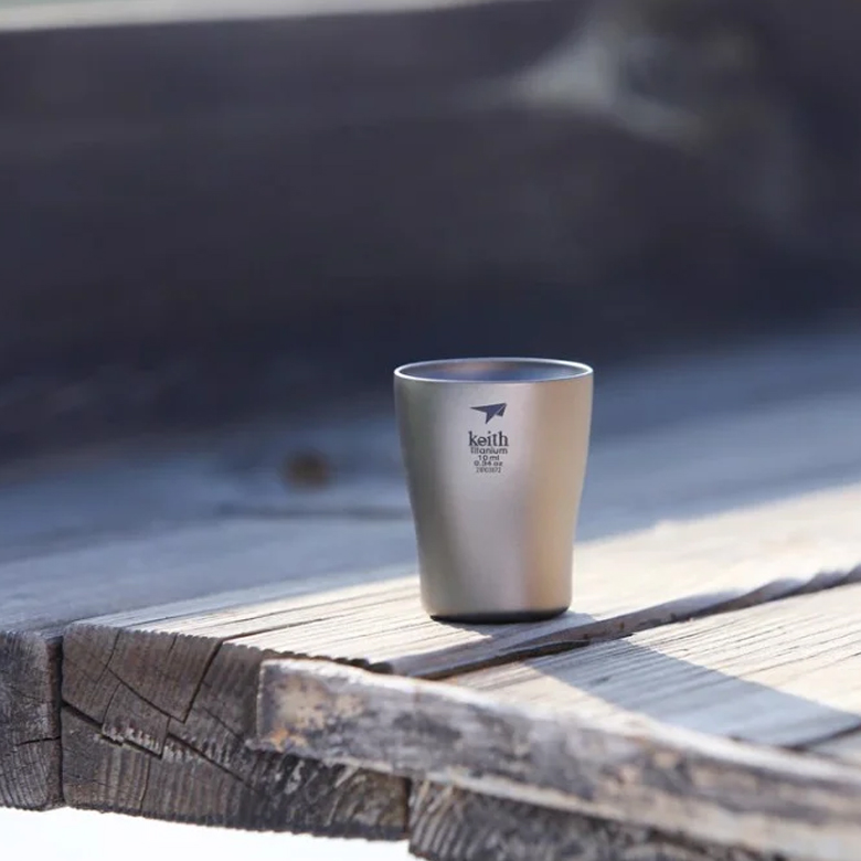 Ly Uống Rượu Keith Titanium Wine Cup 10ml một ly trên bàn gỗ ngoài trời, nền tối