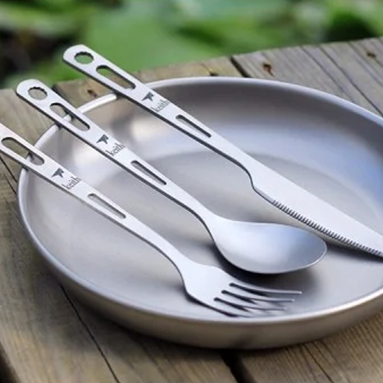 Bộ dao muỗng nĩa titanium đặt trên đĩa ngoài trời