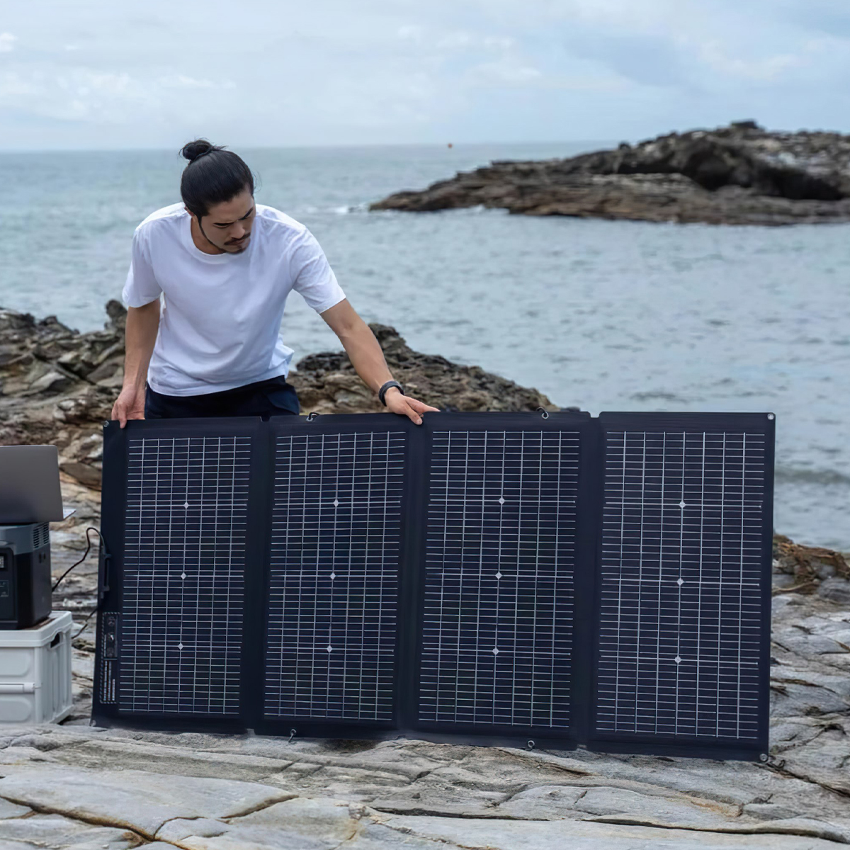 Người đàn ông dựng tấm pin năng lượng mặt trời EcoFlow 220W trên tảng đá ven biển