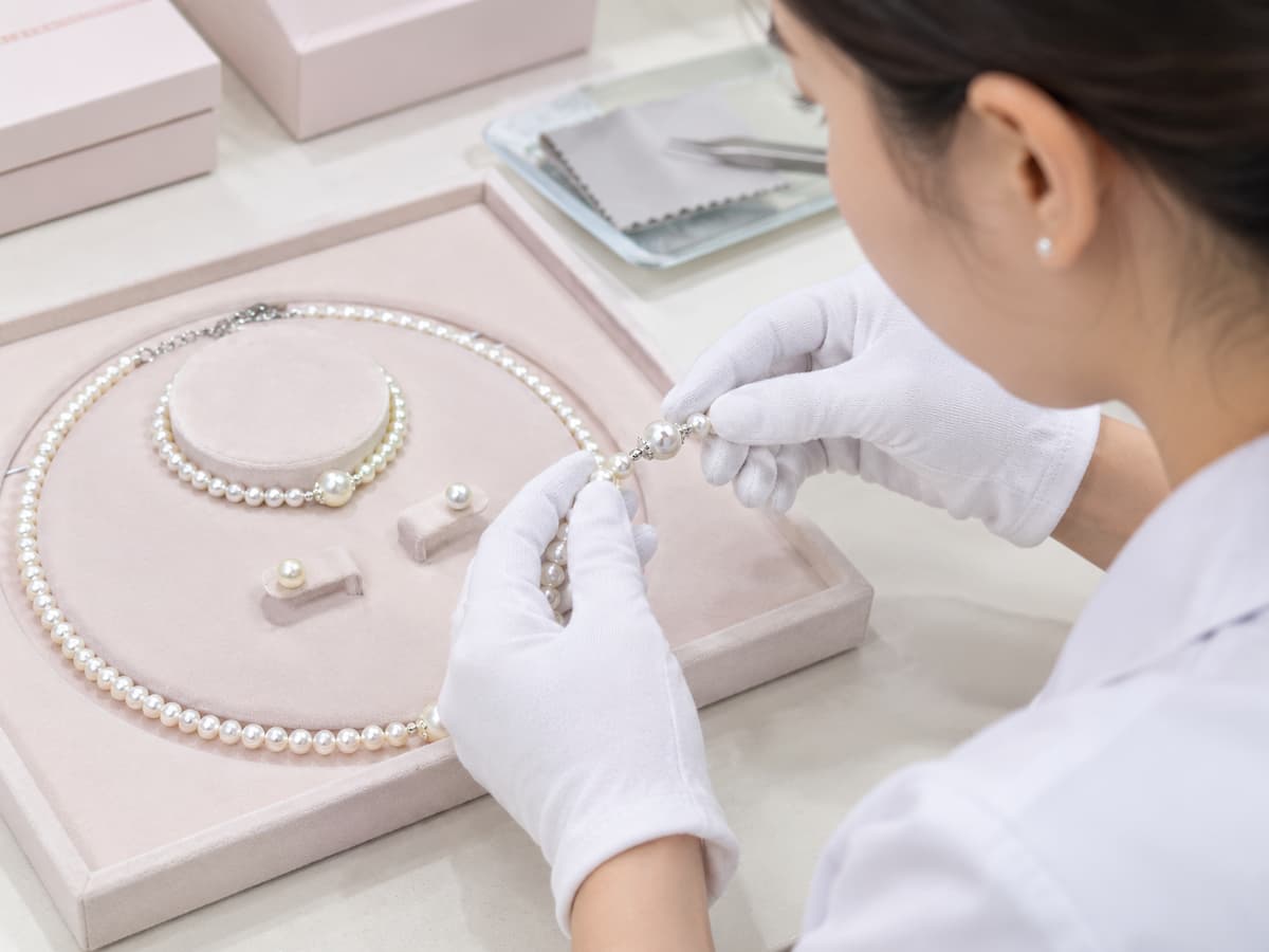Nhân viên kiểm tra bộ trang sức ngọc trai BTSNT261 trước khi đóng gói, tập trung vào tình trạng chuỗi và các chi tiết kết nối.