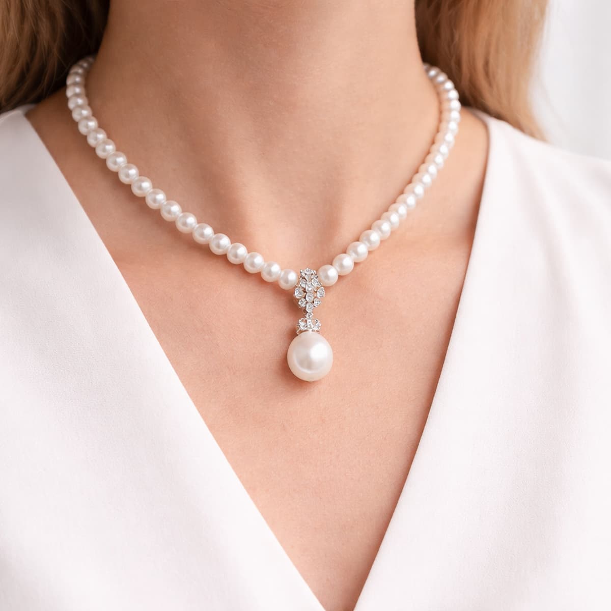 Vòng cổ ngọc trai có mặt tạo điểm nhấn trung tâm trên outfit tối giản