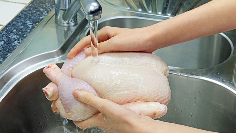 Ảnh 2: Rửa thật sạch gà dưới vòi nước để loại bỏ mùi hôi