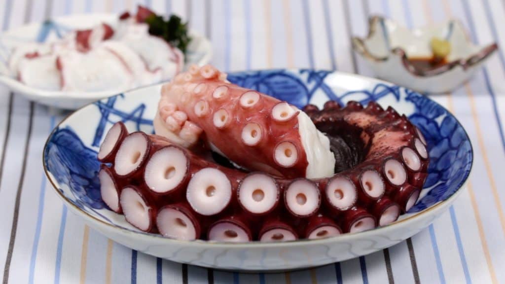 Món sashimi bạch tuộc khổng lồ tươi, thái lát mỏng, trình bày đẹp mắt cùng gừng, mù tạt và nước tương Nhật