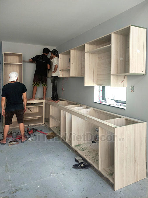 Tủ bếp hiện đại chữ L, gỗ công nghiệp An Cường, khung MDF chống ẩm phủ melamine, cánh MDF chống ẩm phủ acrylic, mặt bếp đá tự nhiên kim sa đen, ốp tường đá marble trắng vân mây - Thi công