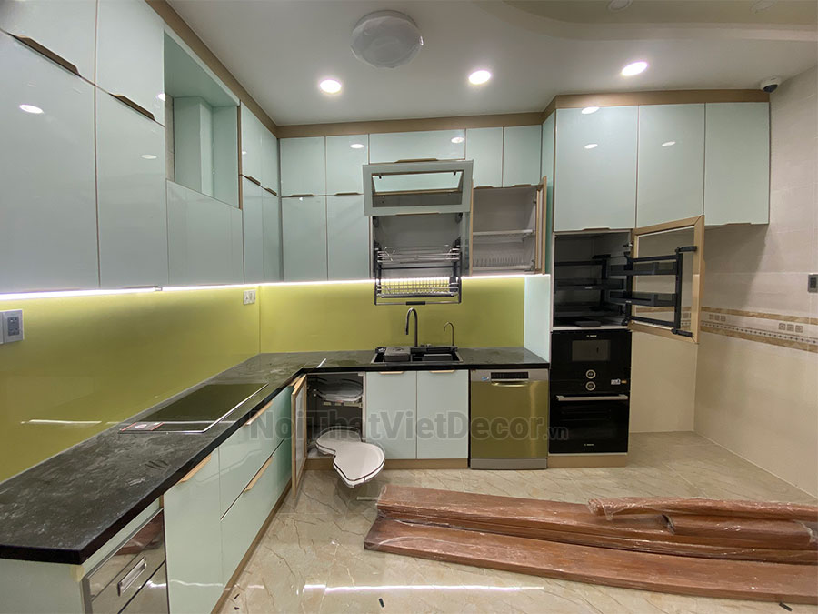 Tủ bếp hiện đại chữ L, khung inox 304 sơn tĩnh điện, cánh kính sơn màu viền nhôm, mặt bếp đá tự nhiên kim sa đen, ốp tường kính cường lực 8mm - Hoàn thiện