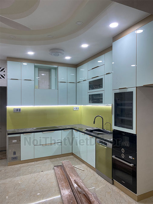Tủ bếp hiện đại chữ L, khung inox 304 sơn tĩnh điện, cánh kính sơn màu viền nhôm, mặt bếp đá tự nhiên kim sa đen, ốp tường kính cường lực 8mm - Hoàn thiện