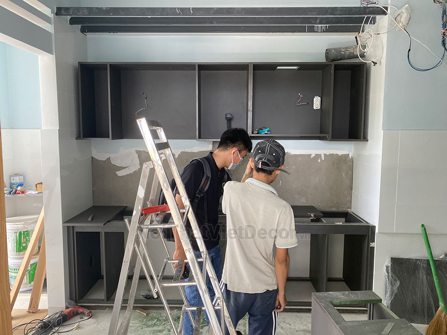 Tủ bếp hiện đại chữ I, gỗ công nghiệp MDF chống ẩm phủ melamine Thanh Thùy, mặt đá tự nhiên kim sa đen, ốp tường kính cường lực 8mm sơn màu - Thi công