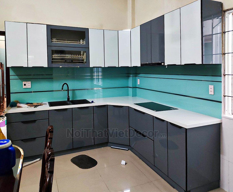 Tủ bếp hiện đại chữ L, khung inox 304 sơn tĩnh điện, cánh kính sơn màu viền nhôm, mặt đá nhân tạo cao cấp Vicostone BQ100, ốp tường kính cường lực 8mmsơn màu chỉ gương - Hình hoàn thiện