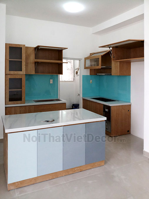 Tủ bếp hiện đại chữ I có đảo, gỗ công nghiệp MDF chống ẩm phủ melamine Thanh Thùy, mặt đá tự nhiên kim sa đen, ốp tường kính cường lực 8mm sơn màu - Hình hoàn thiện