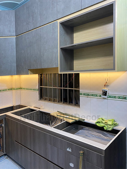 Tủ bếp hiện đại chữ L, tủ dưới nhựa phủ PVC, tủ trên mdf chống ẩm phủ melamine Thanh Thùy, mặt đá nhân tạo cao cấp Vicostone BQ1080, ốp tường kính cường lực 8mm sơn màu - Hoàn thiện